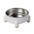 Green stainless steel pet bowl with non-slip base and raised high foot on a wooden floor.