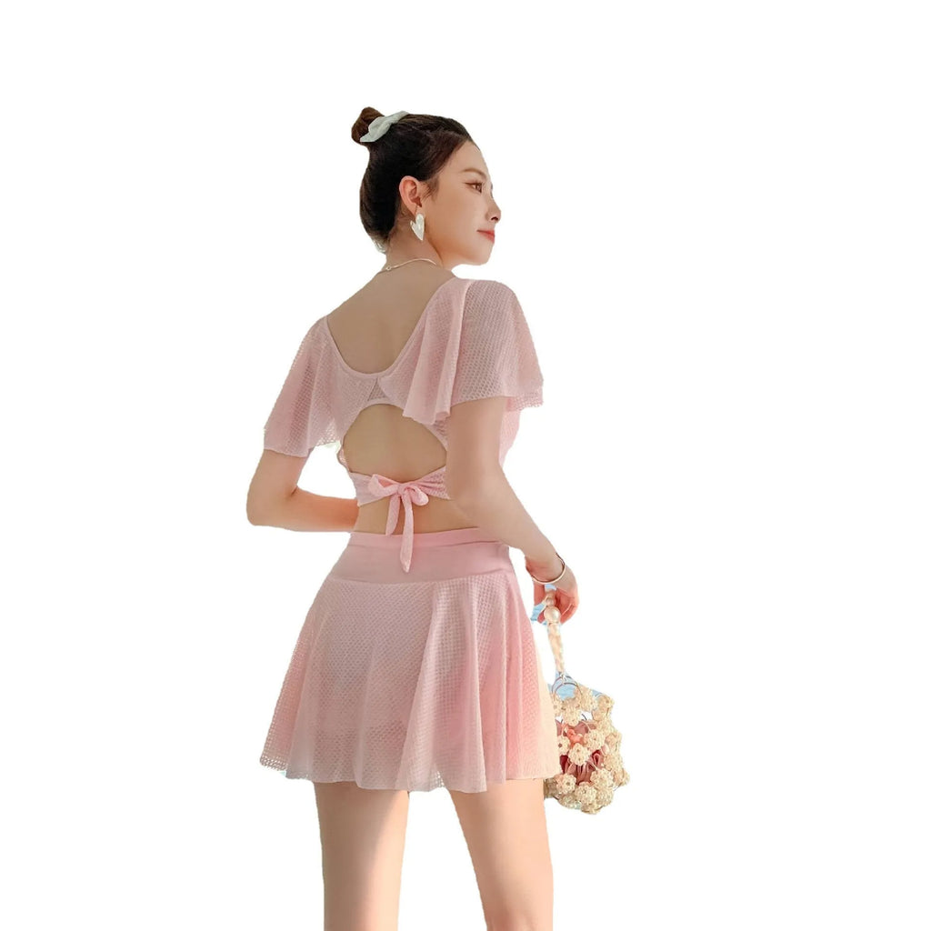Women's solid colour two-piece swimsuit with a separate top and skirt.
