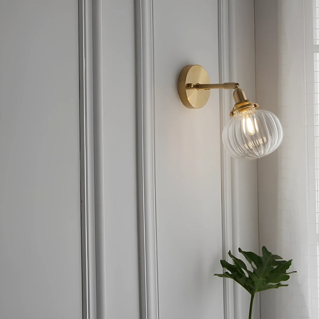 Hand-blown transparent water ripple glass wall lamp mounted on a beige wall, emitting a soft amber glow