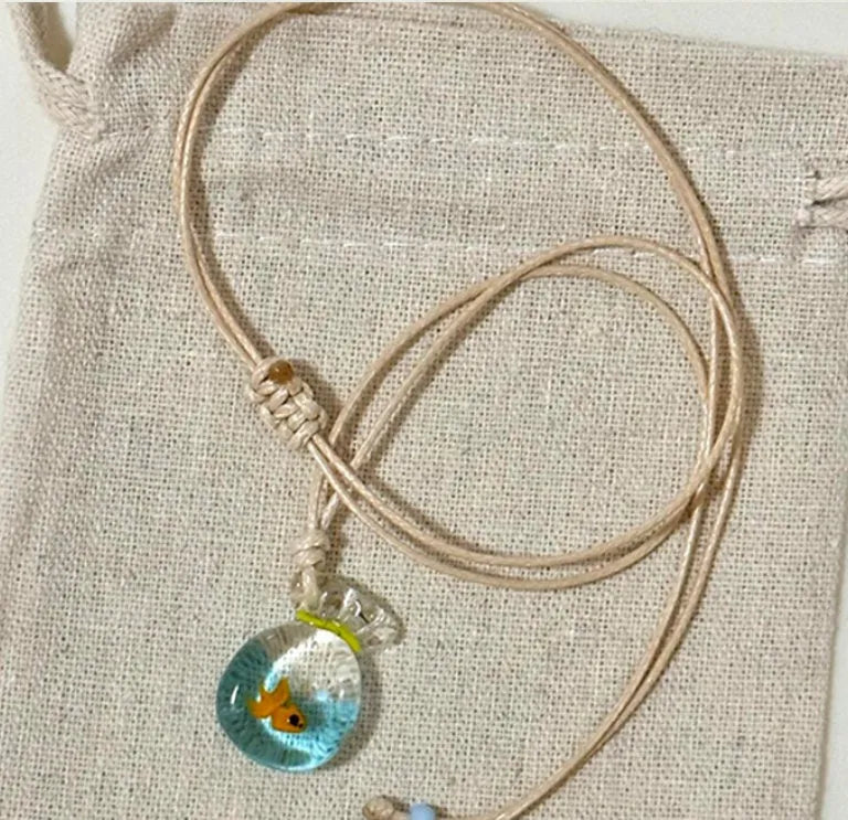 Women's joker motif pendant necklace on a braided cotton and linen clavicle chain.