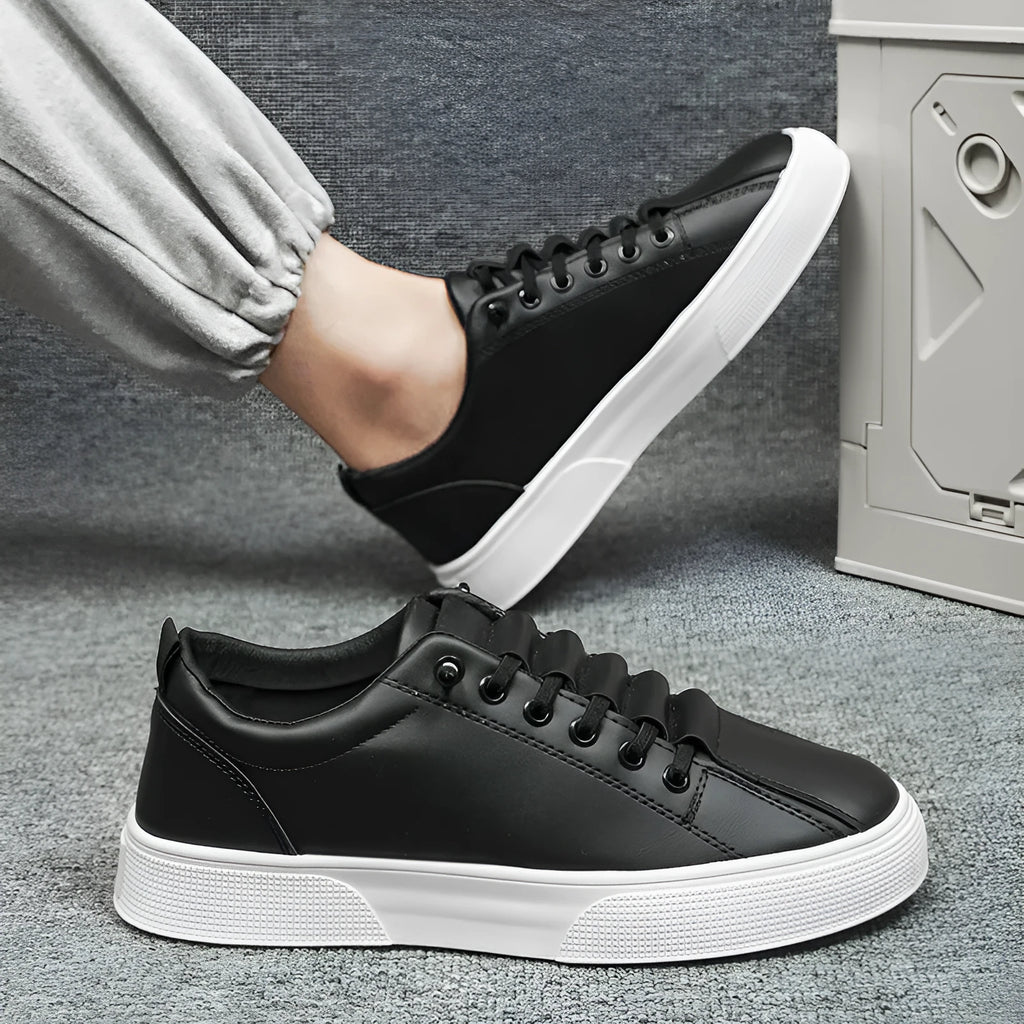 Men's black and white low top synthetic leather sports shoes with mesh panels and a PVC sole.