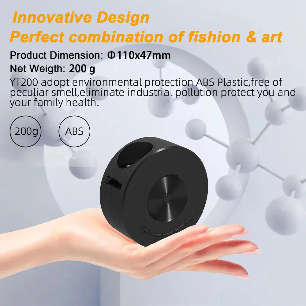 Black portable mini projector for children next to a mobile phone on a table.