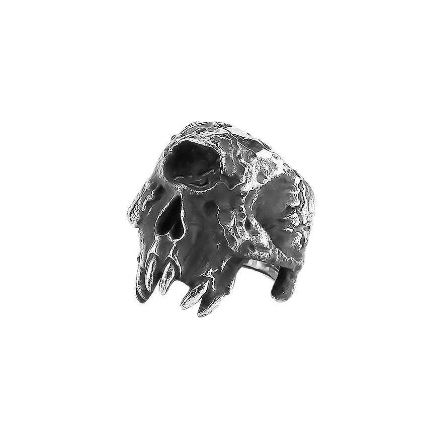 A silver-toned alloy ring featuring a detailed one-eyed skull design on a black background.