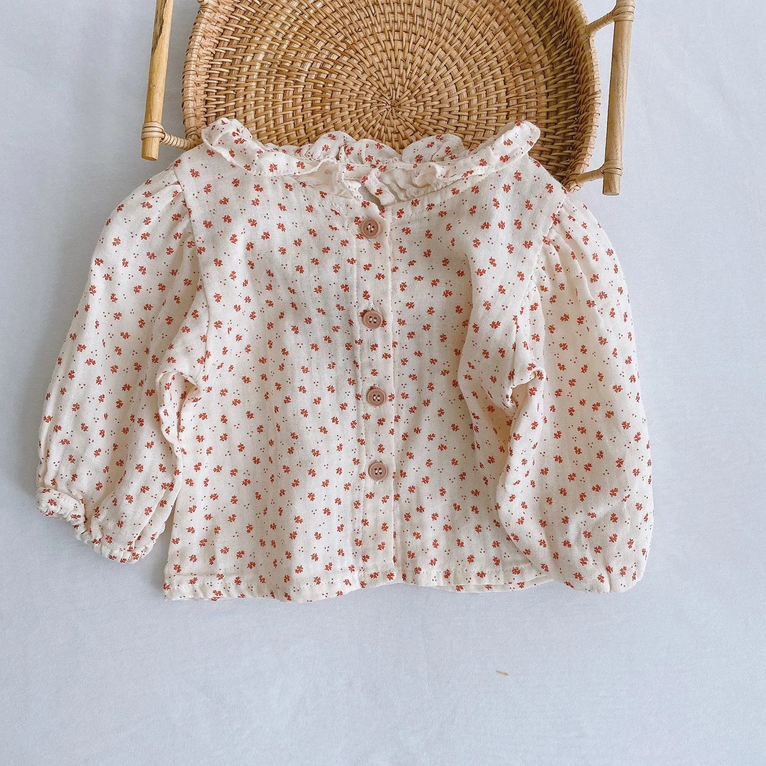 Baby girl wearing a cotton pleated skirt romper with lotus leaf sling design in apricot colour