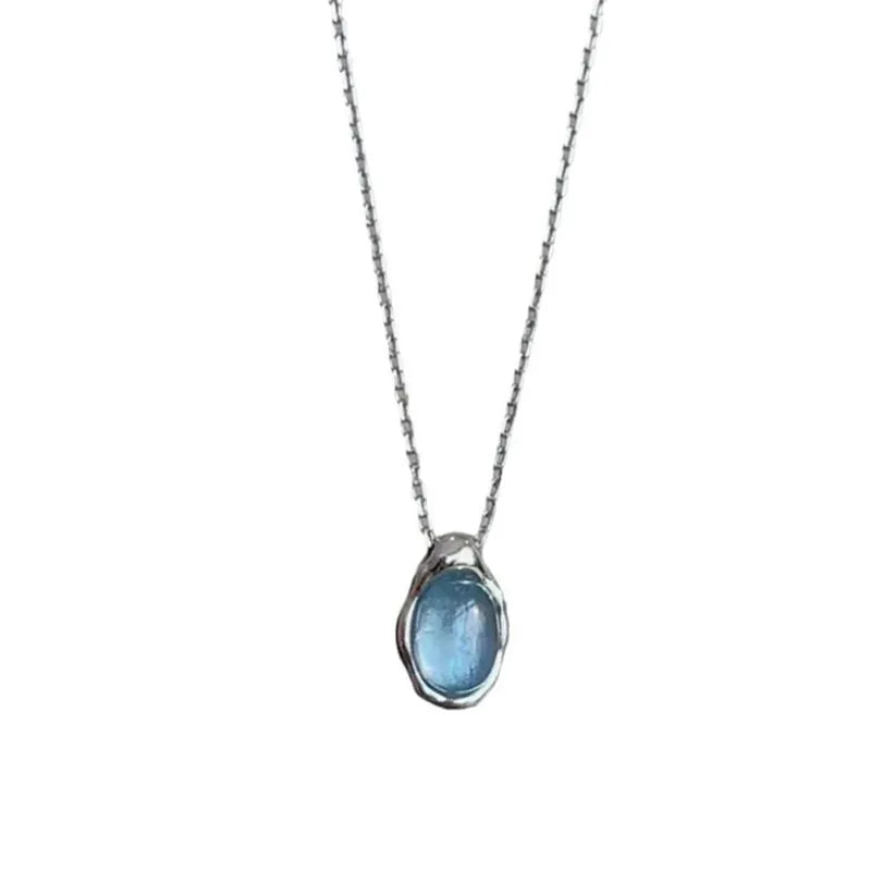 Close-up of a navy blue geometric water drop pendant on an adjustable silver-tone chain