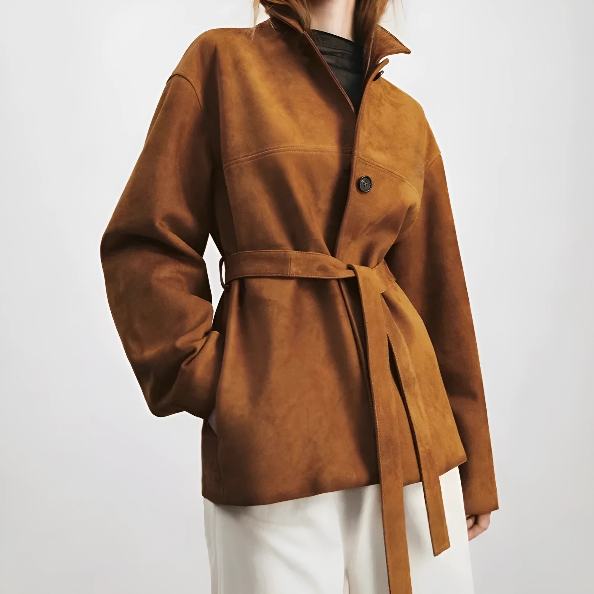 Yellow brown cashmere mid-length coat with a leather belt and a flat Peter Pan collar on a hanger.
