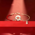 Festive Koi women's bracelet with red rope and peace buckle closure on a wrist.
