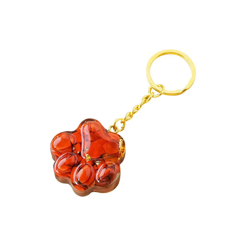 Natural crystal cat's paw keychain pendant in pink crystal, showing detailed 3D carving and metal keyring.