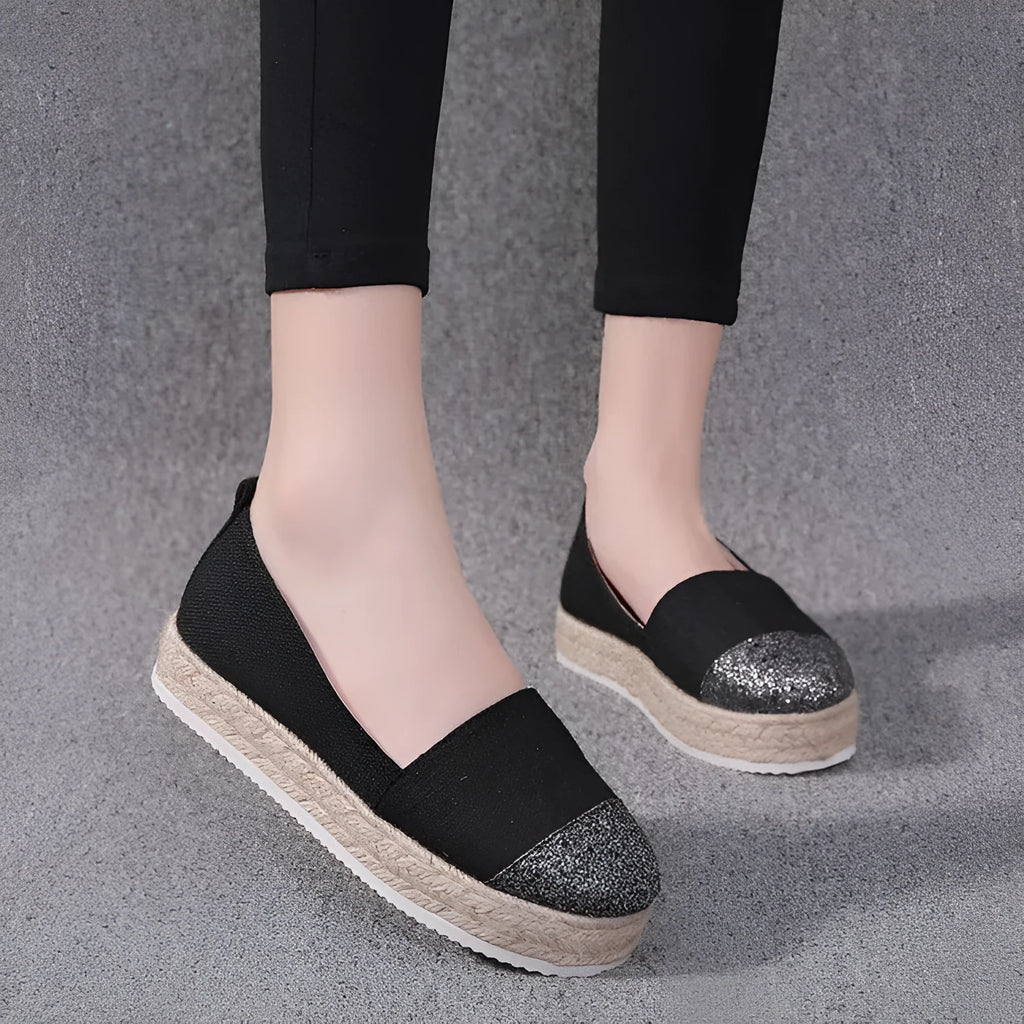 Plus size beige canvas slip-on flat shoes with a round toe on a white background.