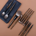 12-piece makeup brush set with wooden handles and a black PU travel case open to show brushes.