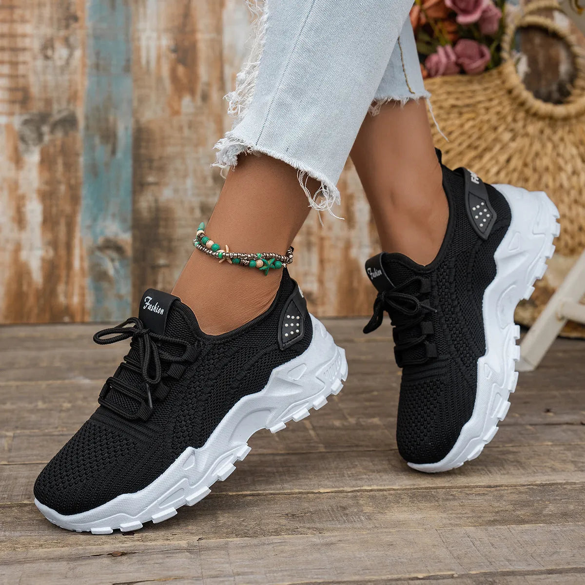 Women's white Flyknit mesh casual sports shoes with flat heel and lace-up front on a plain background.