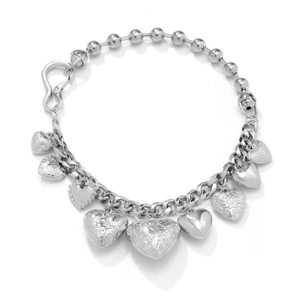 Gold tone carved heart-shaped pendant on an adjustable metal chain necklace.