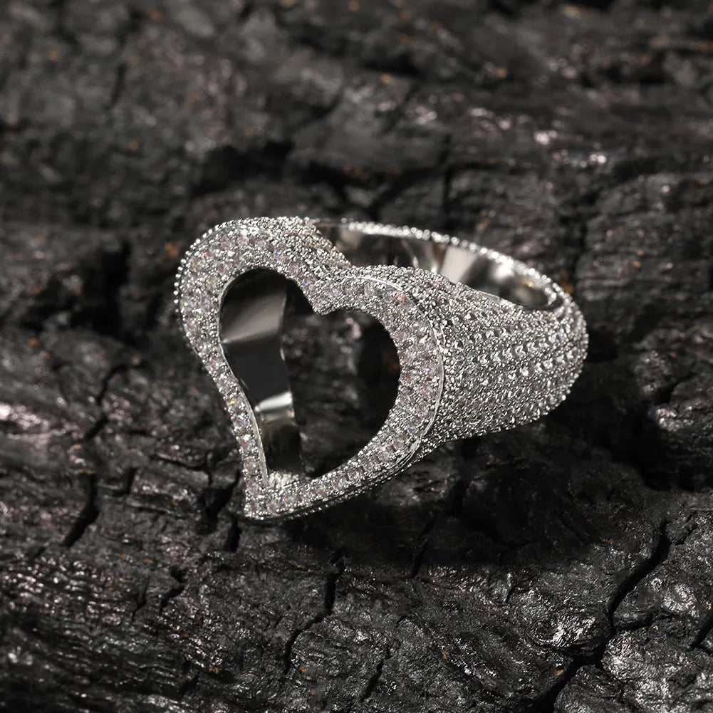 Gold copper ring with hollow heart cut-out and zircon stone on finger