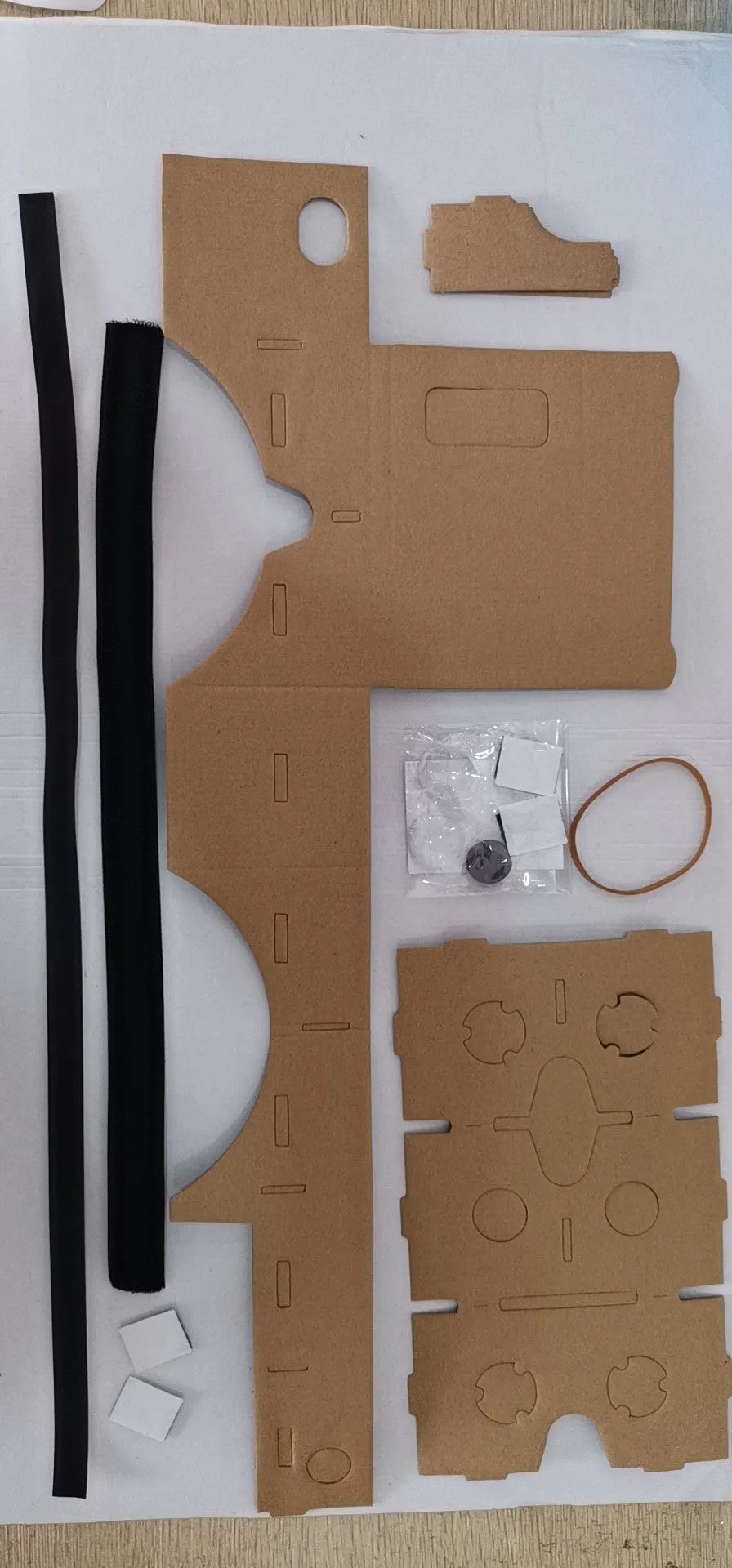 Pink and white cardboard VR glasses with 3D lenses and a rubber head strap for smartphones.