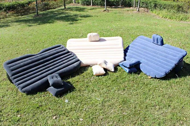 Inflatable car bed with flocked surface and pillows, set up in the back of a five-seater vehicle.