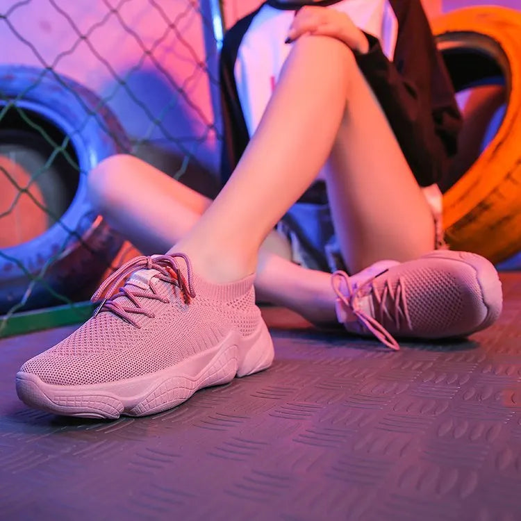 Women's white thick-soled sports shoes with flying woven upper and front strap.