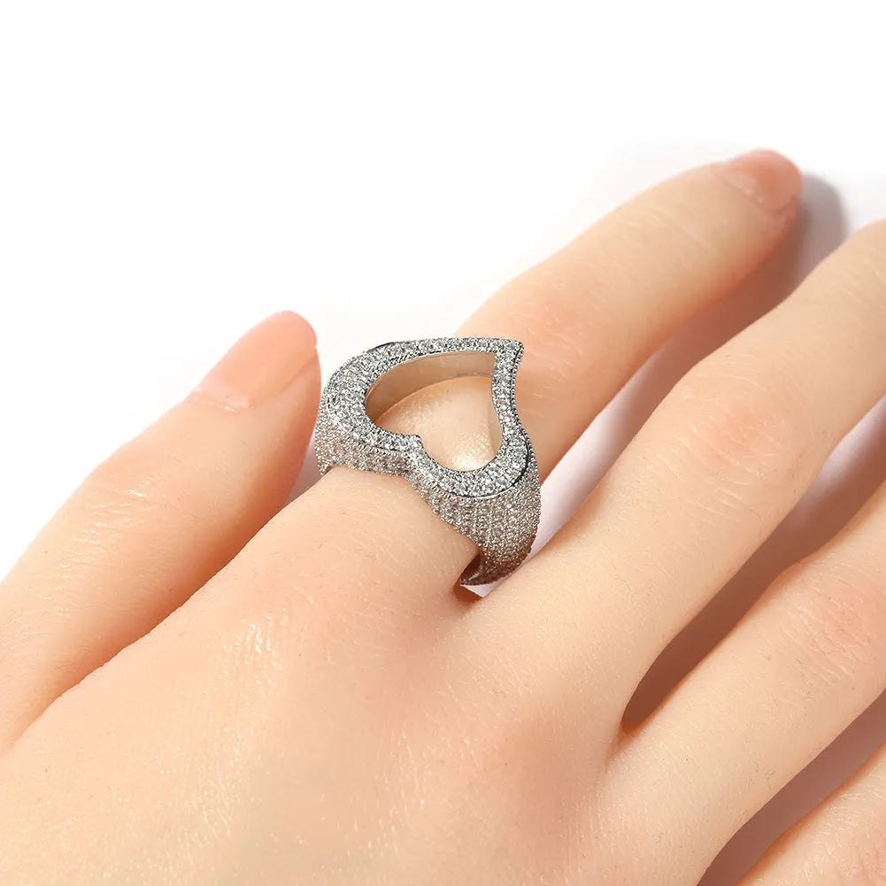 Gold copper ring with hollow heart cut-out and zircon stone on finger