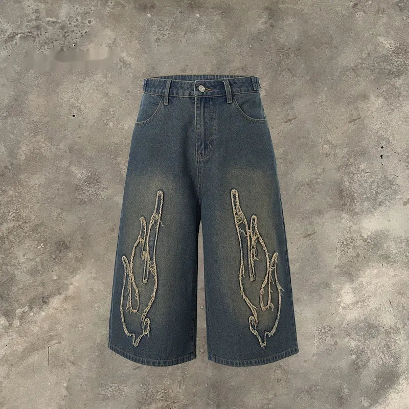 Men's black cropped denim shorts with flame embroidery patch on leg