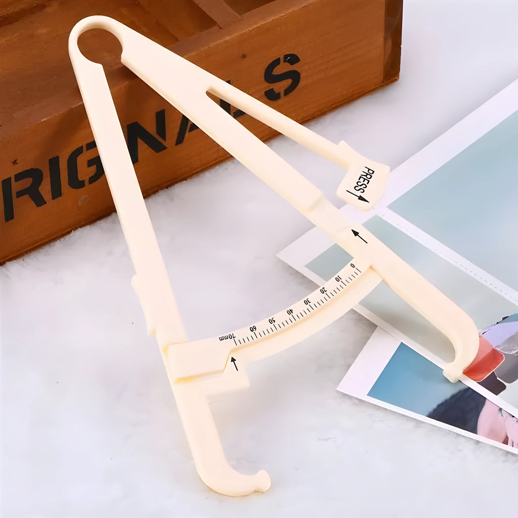 Acrylic skin fold caliper body fat measuring instrument showing scale and measurement jaws