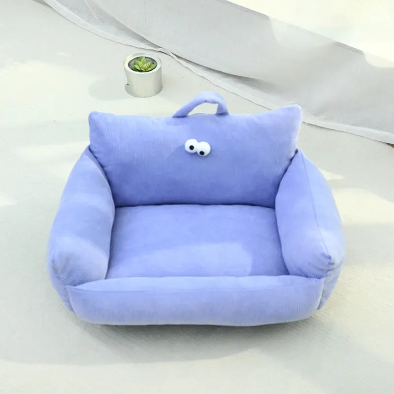 Cartoon big eye pet bed cushion for small dogs and cats in blue, shown with removable sticky eyes.
