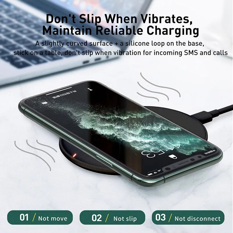 Baseus Rough 15W wireless charging pad in black on a table next to a mobile phone.