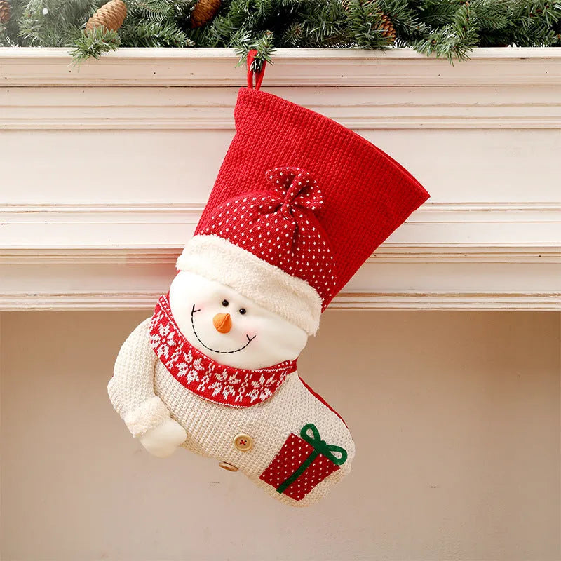 Large red and white knitted Christmas stocking with Santa Claus or Snowman design on a fireplace mantel
