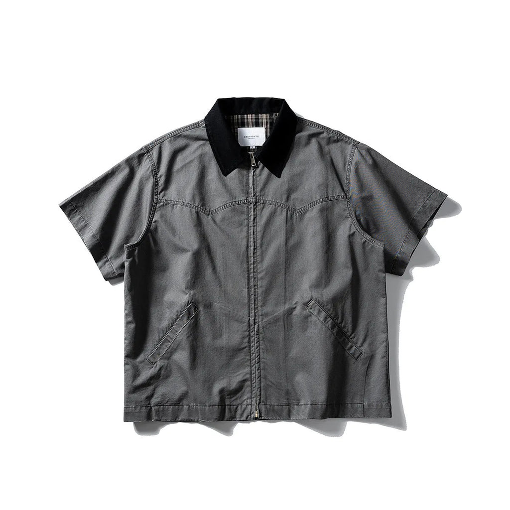 Washed grey cotton overalls shirt with short sleeves and a loose cardigan style on a hanger.