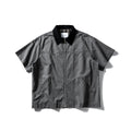 Washed grey cotton overalls shirt with short sleeves and a loose cardigan style on a hanger.