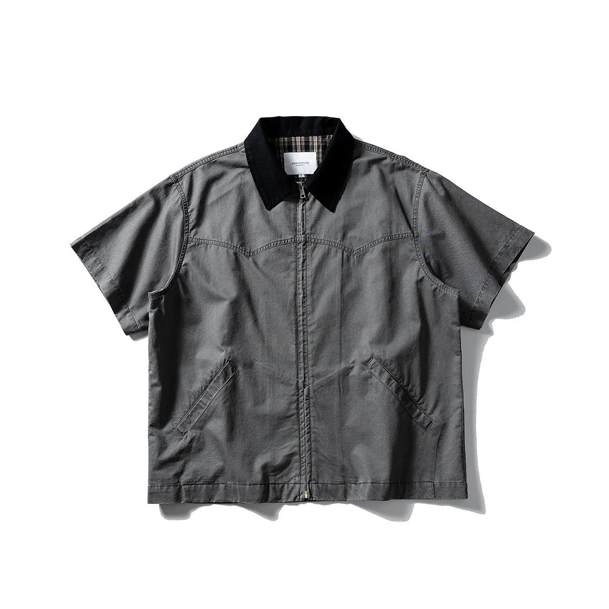 Washed grey cotton overalls shirt with short sleeves and a loose cardigan style on a hanger.