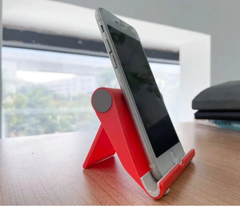 Black folding PE plastic mobile phone and tablet stand holding a smartphone at an angle.
