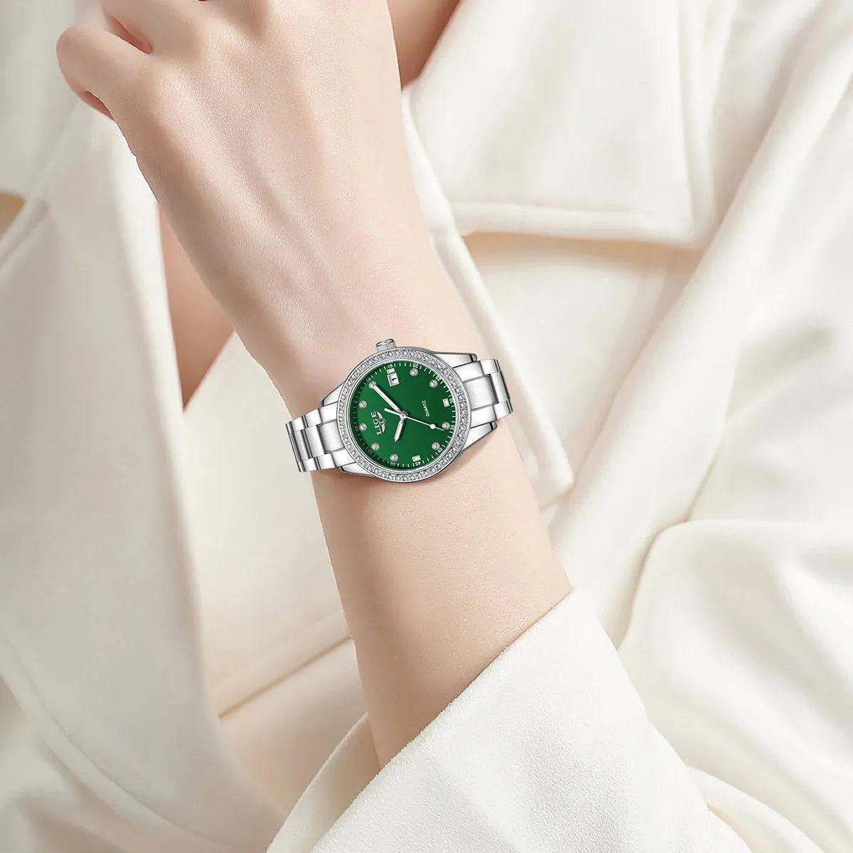 Silver women's quartz watch with diamond bezel and luminous hands on a stainless steel band.