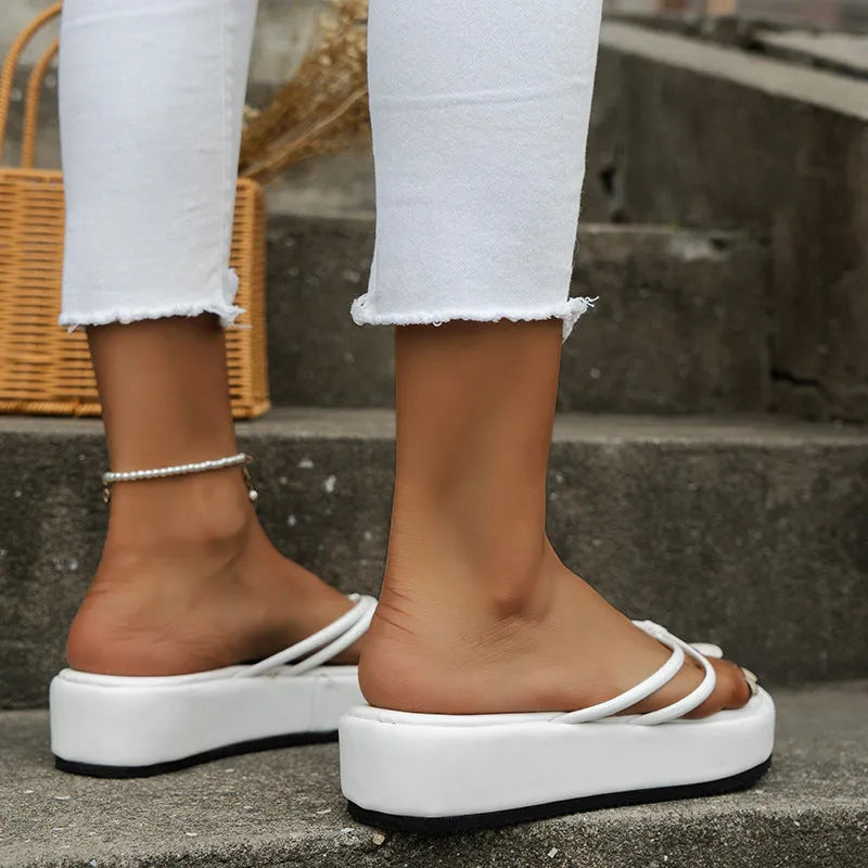Pair of thick-soled herringbone pattern flip-flops in a chosen colour on a plain background.