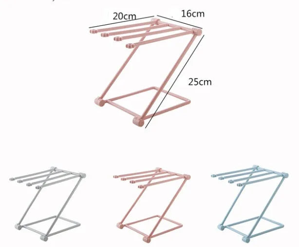 Light grey foldable plastic dishcloth shelf mounted on a wall holding towels.