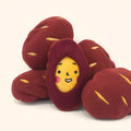 Red sweet potato pet toy with peelable exterior revealing hidden food pocket for treat dispensing