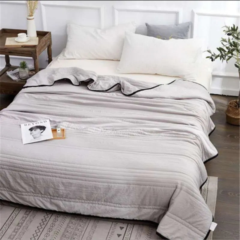 Lightweight seersucker summer quilt in various colours on a bed