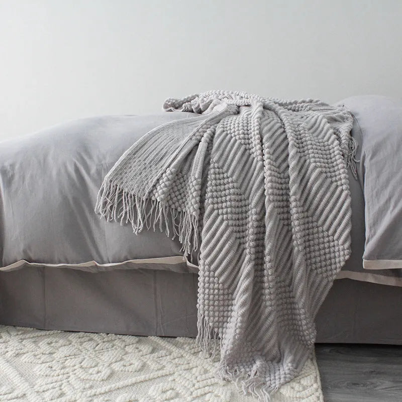 Small light grey polyester nap blanket folded, showing its texture and size.