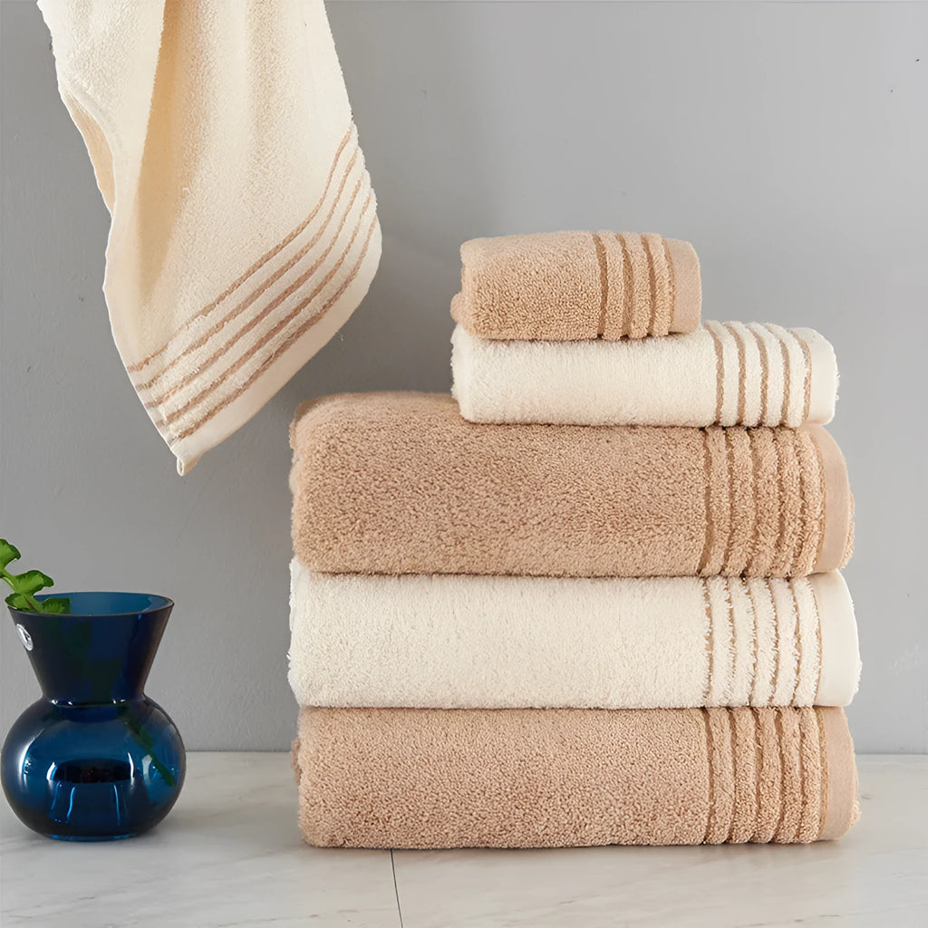 Beige and brown cotton towel set showing bath towel, hand towel, and face cloth sizes