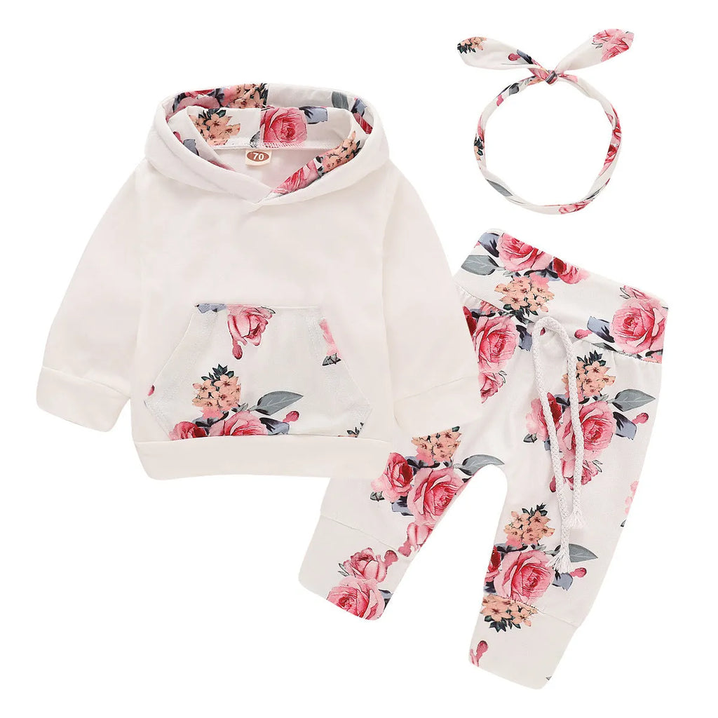 White cotton hooded romper suit for a baby girl with long sleeves and trouser legs.