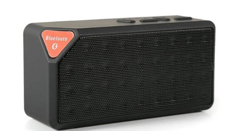 Small cube-shaped wireless Bluetooth speaker in multiple colours showing its compact, waterproof design