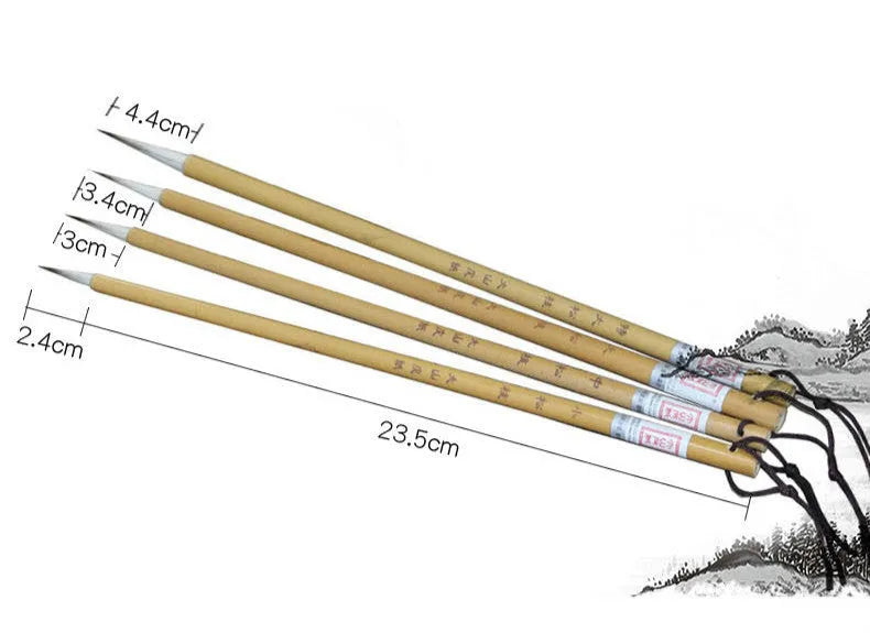 Four gold-coloured thin writing brushes with pine branch design, size 0, on a flat surface.
