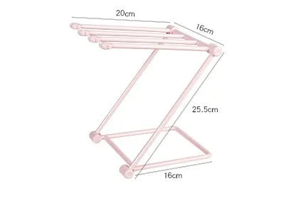 Light grey foldable plastic dishcloth shelf mounted on a wall holding towels.