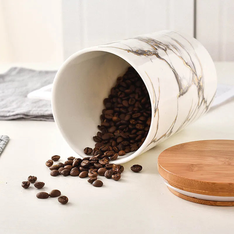 3 piece marbled ceramic jar set with wooden lids large medium and small on a countertop