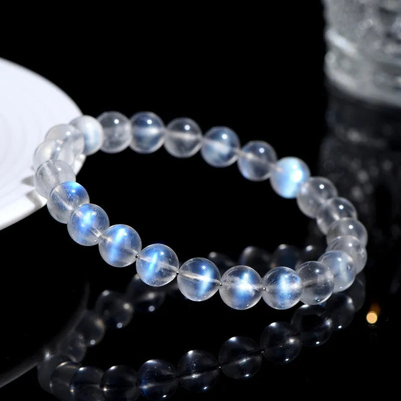 Natural blue moonlight crystal bracelet with cream body beads on a white background.