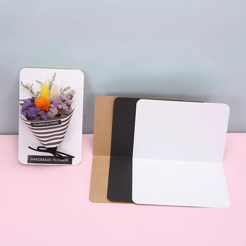 Pack of 100 folded kraft paper greeting cards in 10x15cm size, showing black, brown, and white colour options.