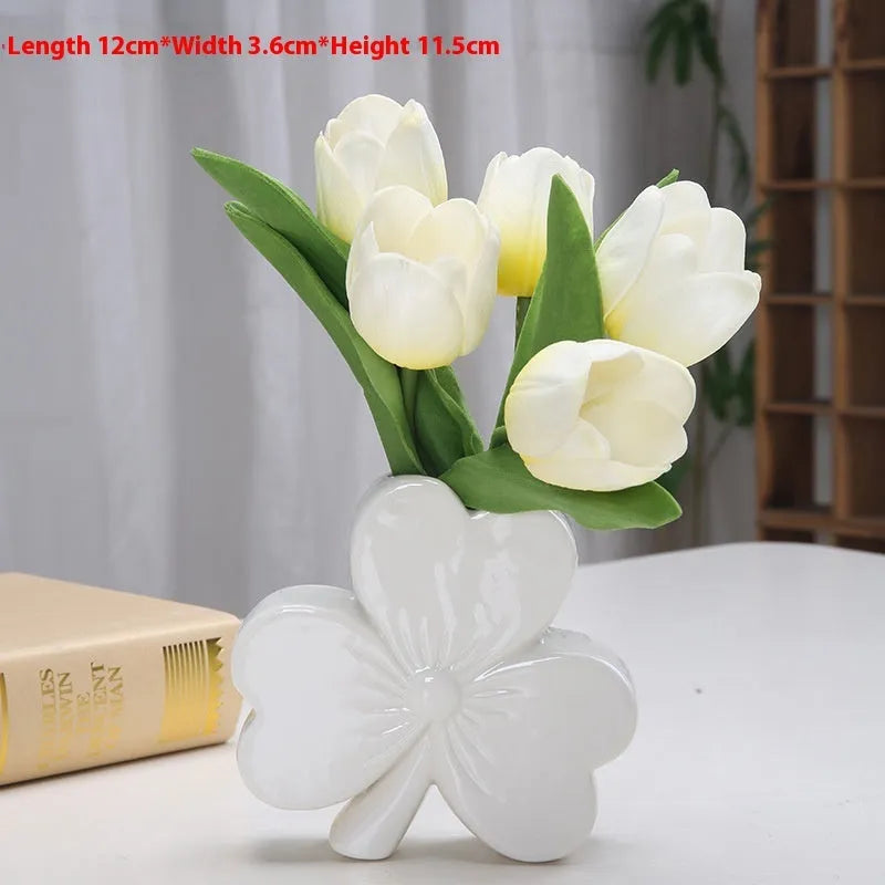 Square white porcelain clover ceramic vase on a desk, shown in light green colour.