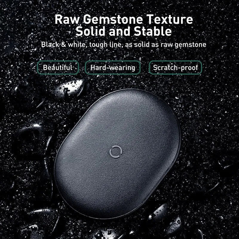 Baseus Rough 15W wireless charging pad in black on a table next to a mobile phone.