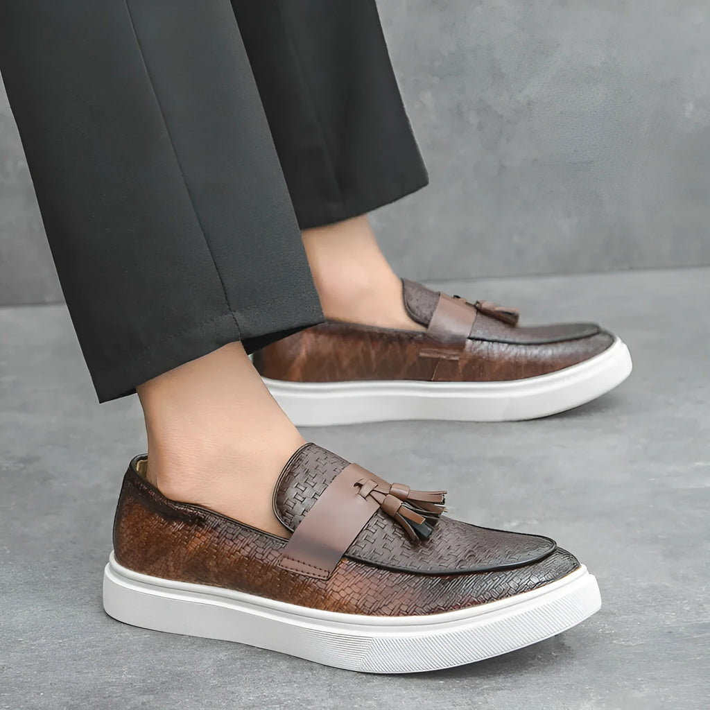 Men's black casual leather shoes with fringe detailing on the upper, round toe, and low heel.
