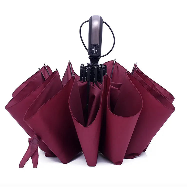 Large black triple-folding automatic umbrella with a rubber handle, shown in the open palace-style position.