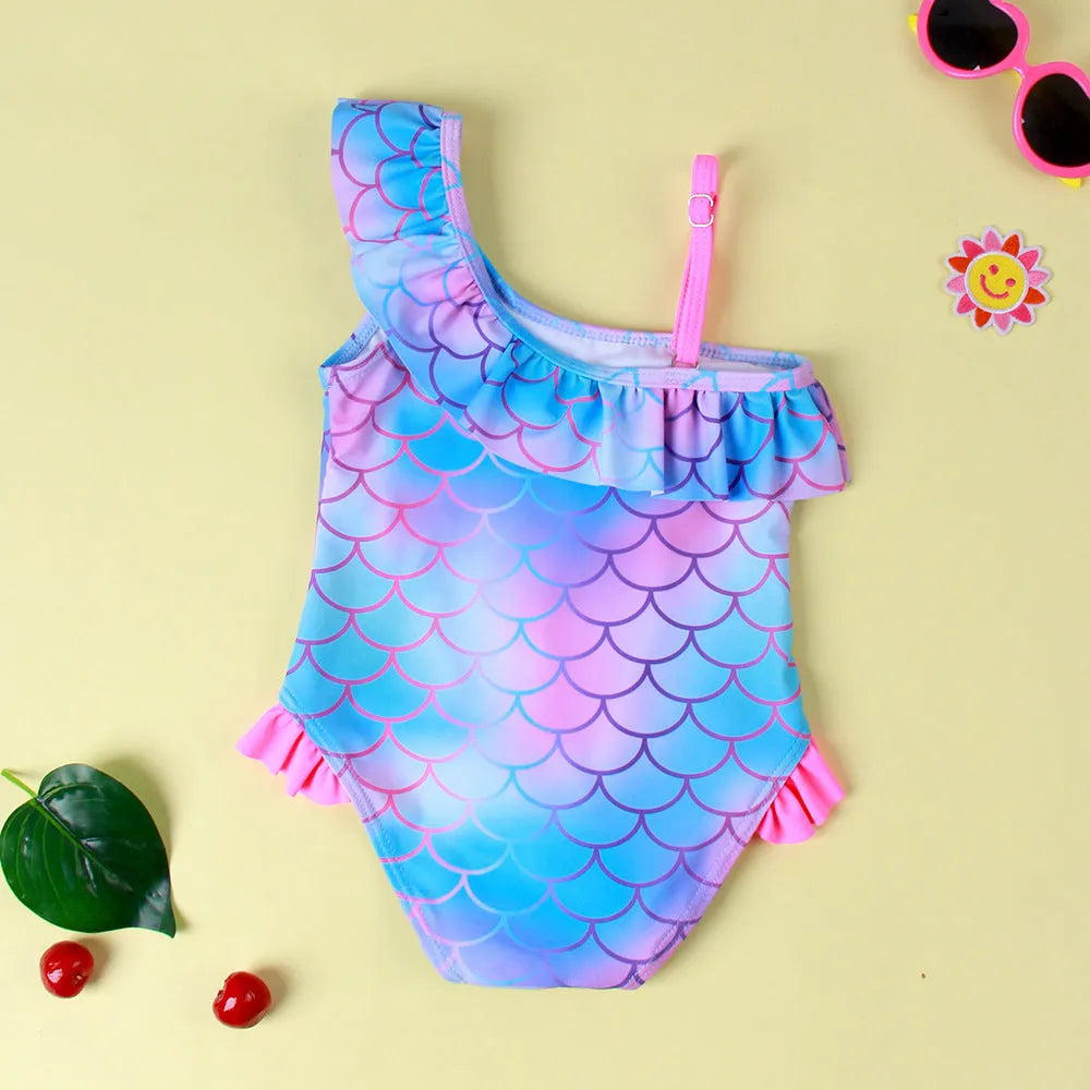 Girls' one-piece swimsuit with blue gradient fish scale print and flounced design.