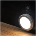 Smart round motion sensor LED light with white housing, shown mounted on a wall.